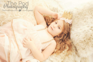 beautiful-child-photographer-brentwood-laying-on-bed-crown-pink-gold-dress
