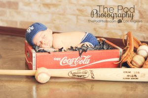 baseball themed newborn photos - baby in coke crate with sports props