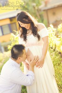 father kissing wife's maternity stomach