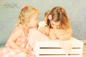 two sisters kissing newborn baby girl los angeles photographer