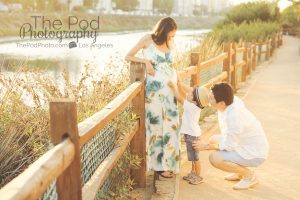 little boy touching moms belly on location