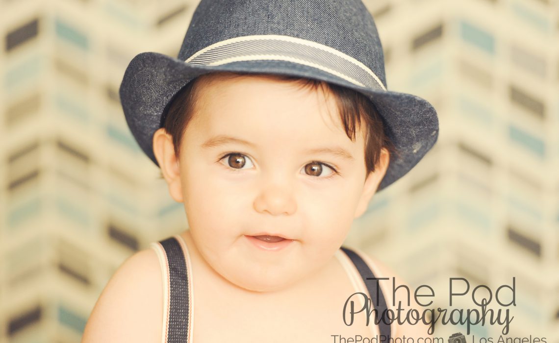 Baby-Boy-Portraits-Los-Angeles-Fedora-Suspenders-Blurry-Background-Close-Up