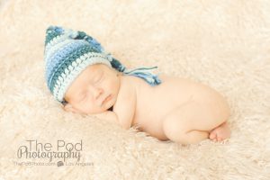 blue elf hat on a sleeping newborn baby boy
