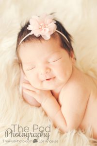 smiling newborn baby with a dimple
