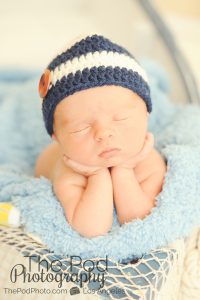 Newborn Boy holding his head in his hands