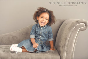 two-year-old-baby-girl-sitting-on-chaise-lounge