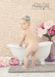 naked-baby-butt-standing-by-miniature-bathtub-with-flowers