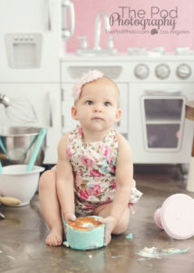 baby-kneeling-holding-smash-cake