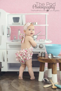 one-year-old-baby-girl-playing-in-kitchen-over-the-shoulder-look