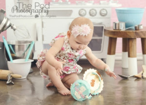baby-knocking-over-first-birthday-smash-cake