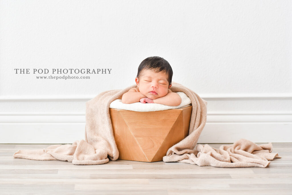 Newborn Baby Studio Photoshoot Hermosa Beach baby boy in a wood box with a beige blanket.