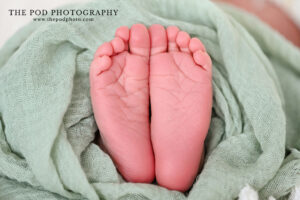 newborn-toes-closeup-wrapped-in-green-muslin