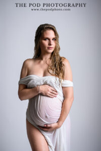 wet-look-maternity-photo-standing-white-dress-powerful-gaze