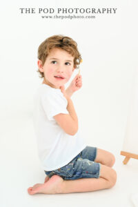 girl-holding-blue-paint-brush-smiling