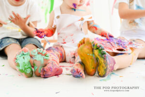 paint-covered-feet-of-three-kids-photo