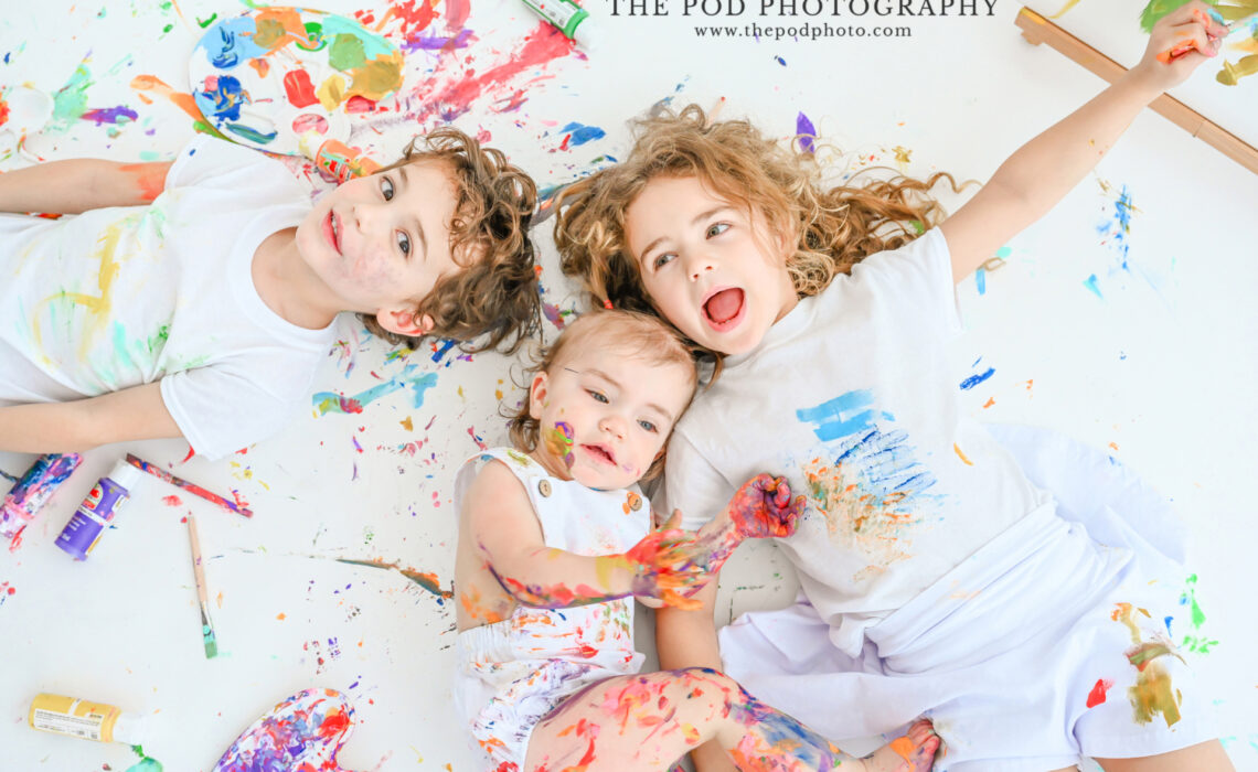 paint-splattered-kids-smiling-on-floor