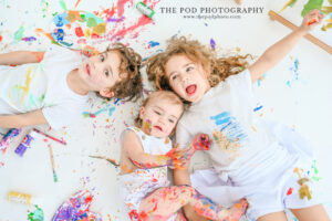 paint-splattered-kids-smiling-on-floor