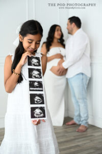 big-sister-ultrasound-parents-in-background-the-pod-photography